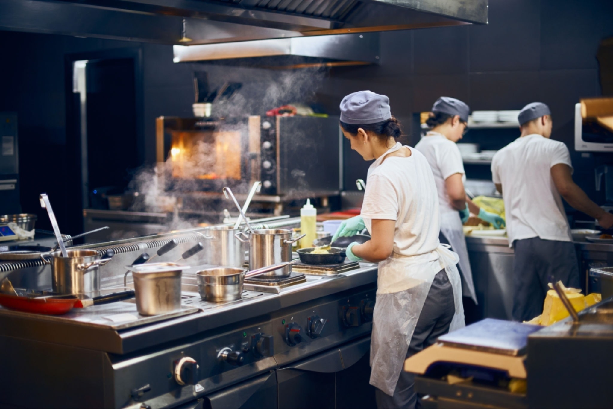 Teen campers practicing knife skills in a professional kitchen